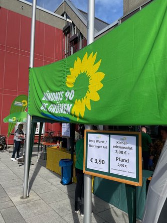 Verkaufsstand der GRÜNEN mit Roter Wurst / Rostbratwurst für 3,90 EUR oder Kichererbsensalat für 3 EUR.